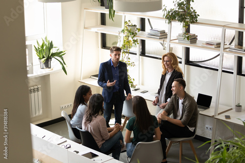 Φωτογραφία Six diverse businesspeople chatting during break in co-working space