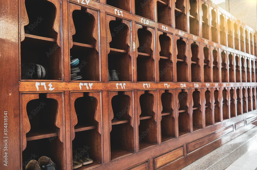 Old wooden shoes pigeon holes for storing shoes. White Arabic numerals (from 0-9) are written on top of each of the pigeon hole.