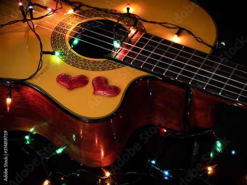 red glitter hearts and glowing string lights on acoustic guitar , Valentine's day concept