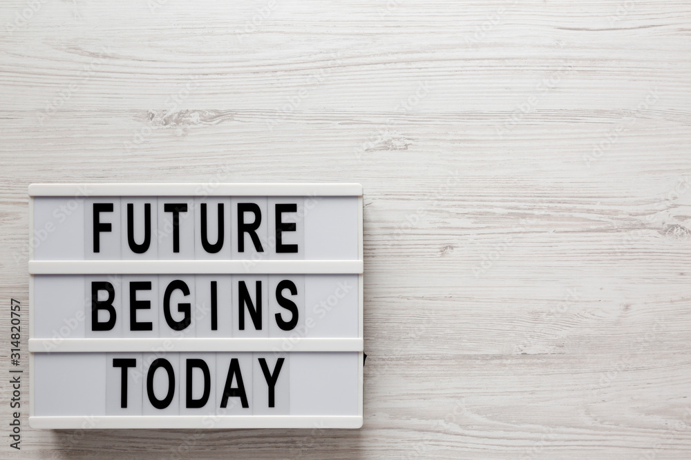 'Future begins today' words on a lightbox on a white wooden surface, top view. Overhead, from above, flat lay. Space for text. 'Future begins today' words on a lightbox on a white wooden surface, top view. Overhead, from above, flat lay. Space for text.