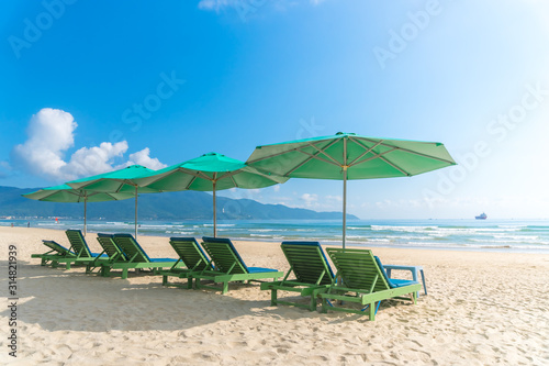 Beach chairs with outdoor umbella at summer beach.