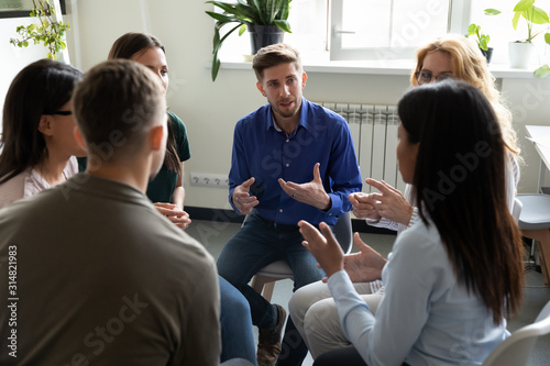 Foto Diverse people seated in circle participating at group therapy session
