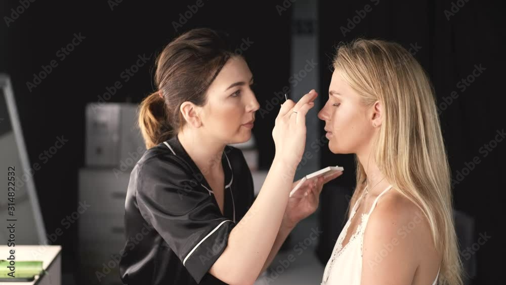 An artist is working in a salon. A client is sitting in a beauty studio. The client has blond hair. An artist is working in a salon. A client is sitting in a beauty studio. The client has blond hair.