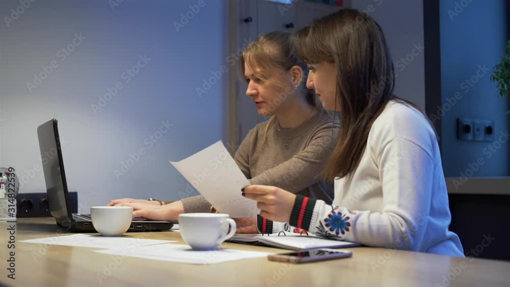 Female Coworkers Working Together in a Coffee Shop in Late Evening. They Discussing Business Strategy and New Projects. Business, People, Paperwork and Working Overtime Concept Female Coworkers Working Together in a Coffee Shop in Late Evening. They Discussing Business Strategy and New Projects. Business, People, Paperwork and Working Overtime Concept
