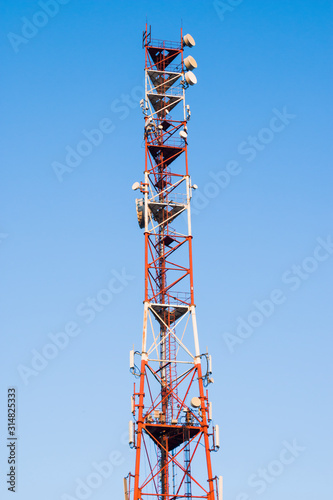Telecommunications tower against a blue sky . Radio and satellite pole. Communication technology. Telecommunication industry. Mobile or telecom 4g network. Antenna on blue sky.