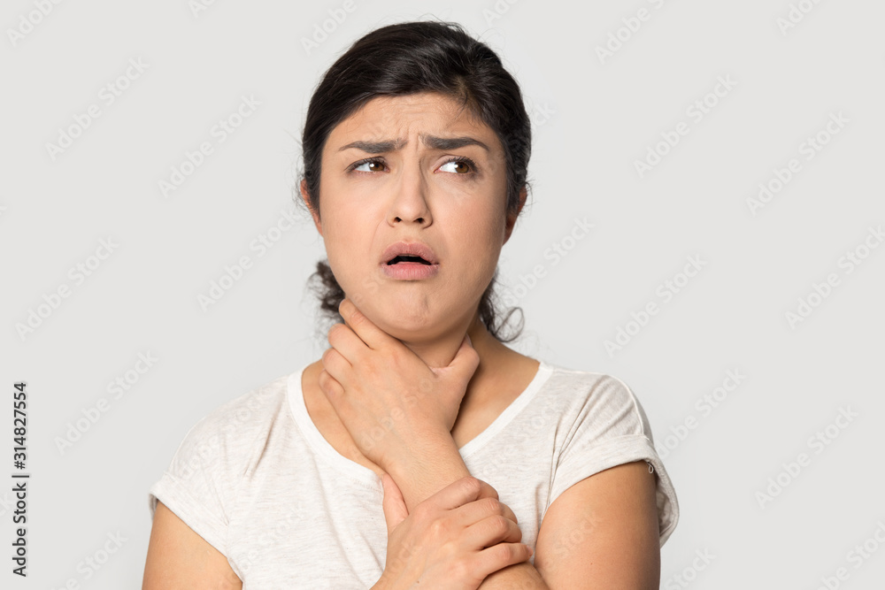Unhealthy indian young girl holding hand on throat. Unhealthy indian young girl holding hand on throat.
