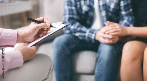 Young couple bonding, specialist writing report in notepad