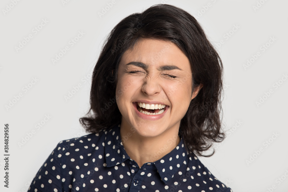Attractive indian ethnicity overjoyed millennial woman burst in laugh. Attractive indian ethnicity overjoyed millennial woman burst in laugh.