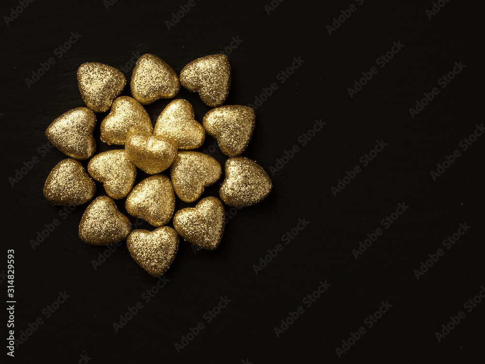 Golden glitter covered hearts design on dark background. Saint Valentine theme. Copy space. Golden glitter covered hearts design on dark background. Saint Valentine theme. Copy space.