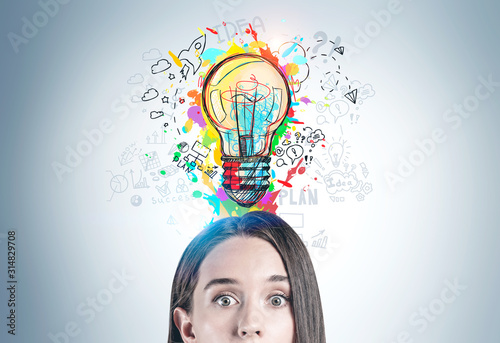 Astonished young woman and her bright idea