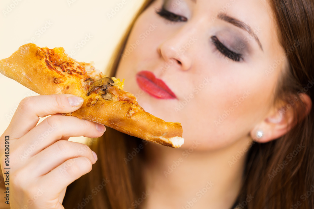 Woman eating hot pizza slice