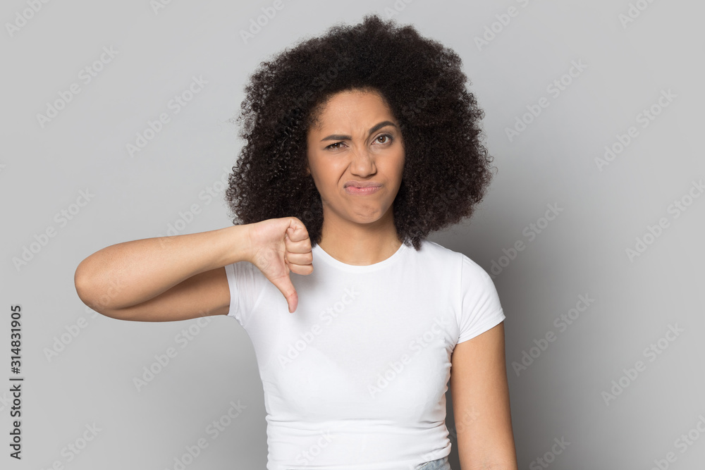 African american frowning female client showing thumbs down gesture. African american frowning female client showing thumbs down gesture.