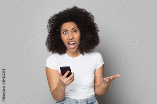 Angry african american woman irritated by broken device, low battery.