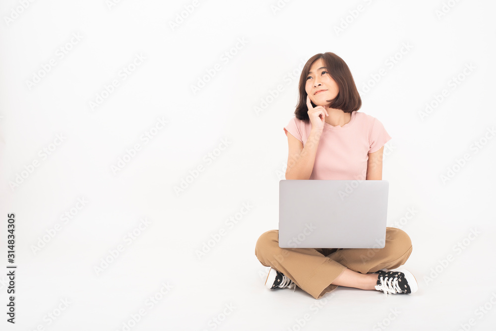Cute Asian teen woman is working with computer on white background Cute Asian teen woman is working with computer on white background