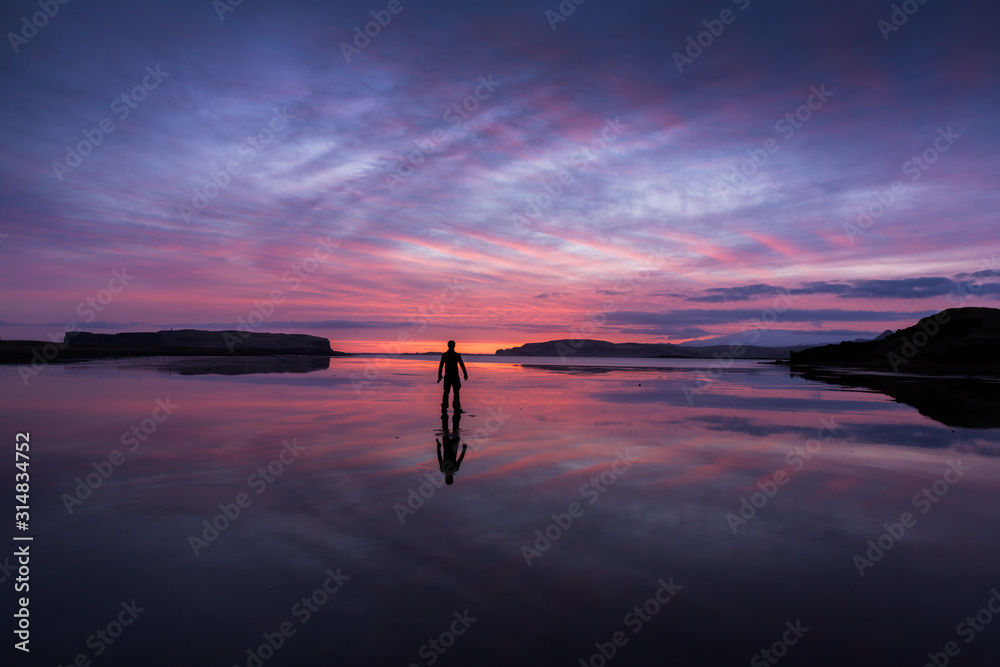 Sunset over a lake in Scandinavia with figure in foreground
