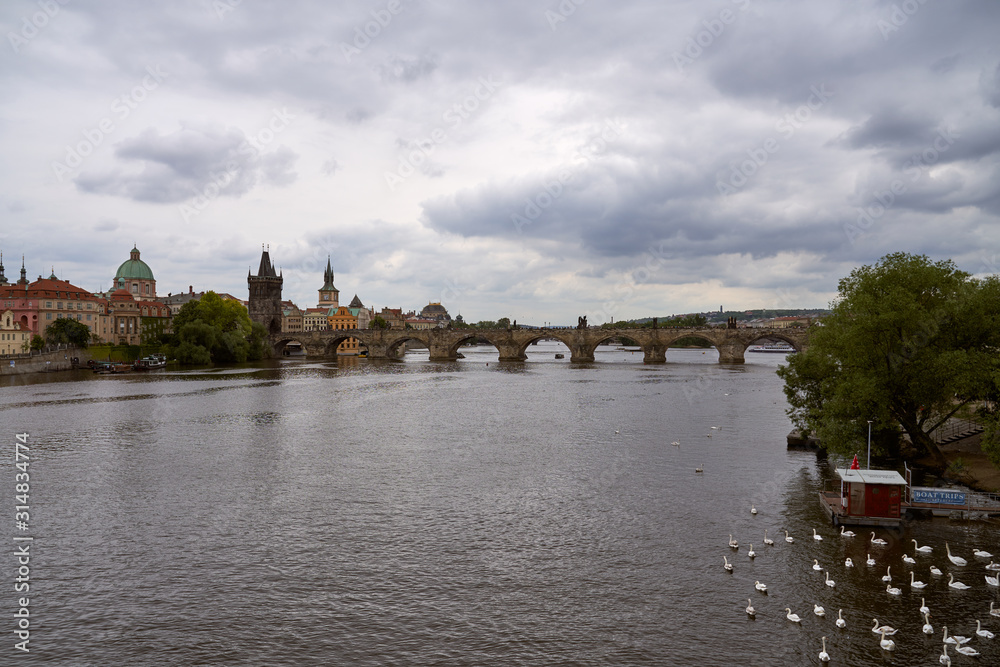 Top view of the wide Vltava river. Horizontal photo of colorful European city of Prague in Czech Republic, evening, cloudy sky, month of may, travel in tourist place.