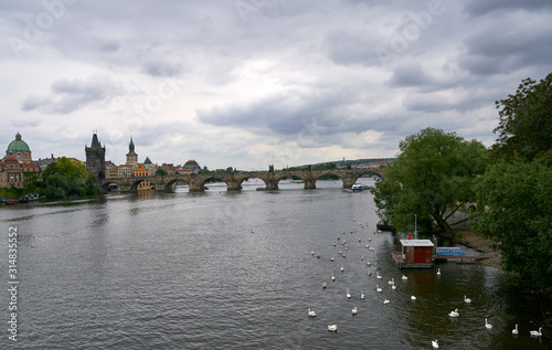 Top view of the wide Vltava river. Horizontal photo of colorful European city of Prague in Czech Republic, evening, cloudy sky, month of may, travel in tourist place.