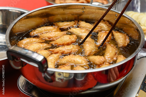Vászonkép deep frying traditional Chinese Yau Kok Zai or sweet dumpling with some raw ones