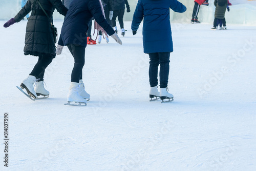People ice skating at a city ice rink on a winter day during the holidays