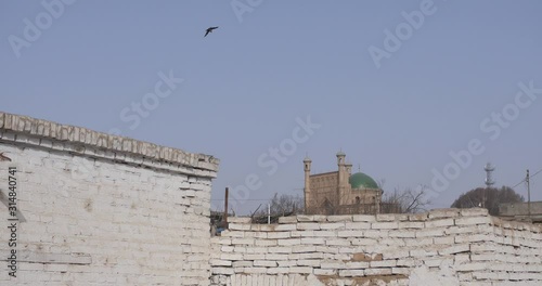 Kuqa, Xinjiang, China - Uyghur Mosque Behind The Old White Wall On A Bright Sunny Weather - Wide Shot photo