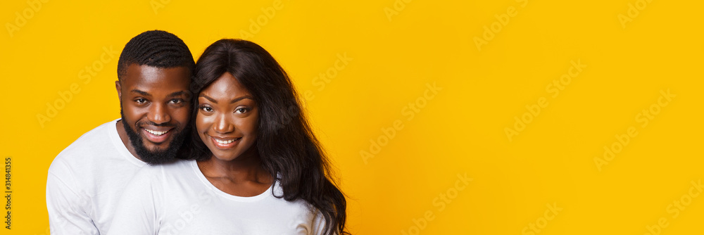 Portrait of happily married black couple posing over yellow background - obrazy, fototapety, plakaty 