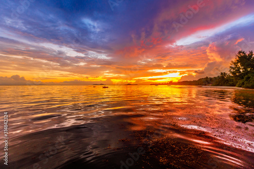 Soft, fluffy and colorful cloud formation in many colors at Grand Anse beach, Praslin Island, Seychelles. Colorful sky with clouds in the evening wallpaper background. photo