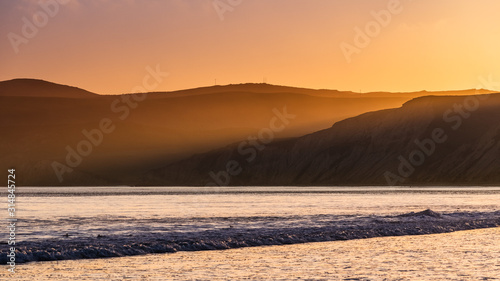 Golden sunset light illuminating the shoreline of the Pacific Ocean  Drakes Beach  Point Reyes National Seashore  California