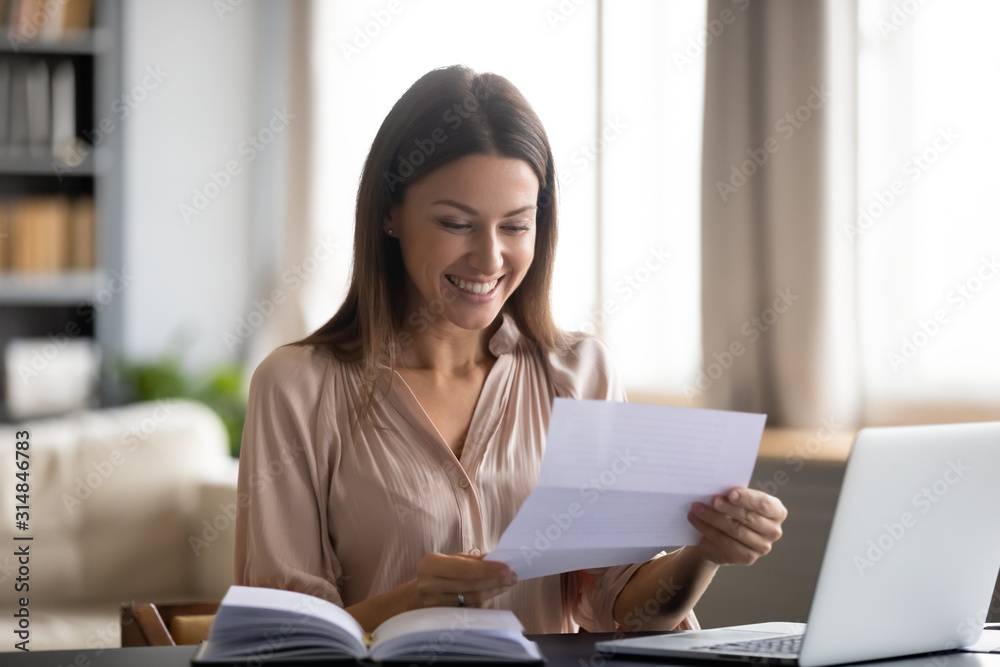 Smiling young woman read good news in letter Smiling young woman read good news in letter
