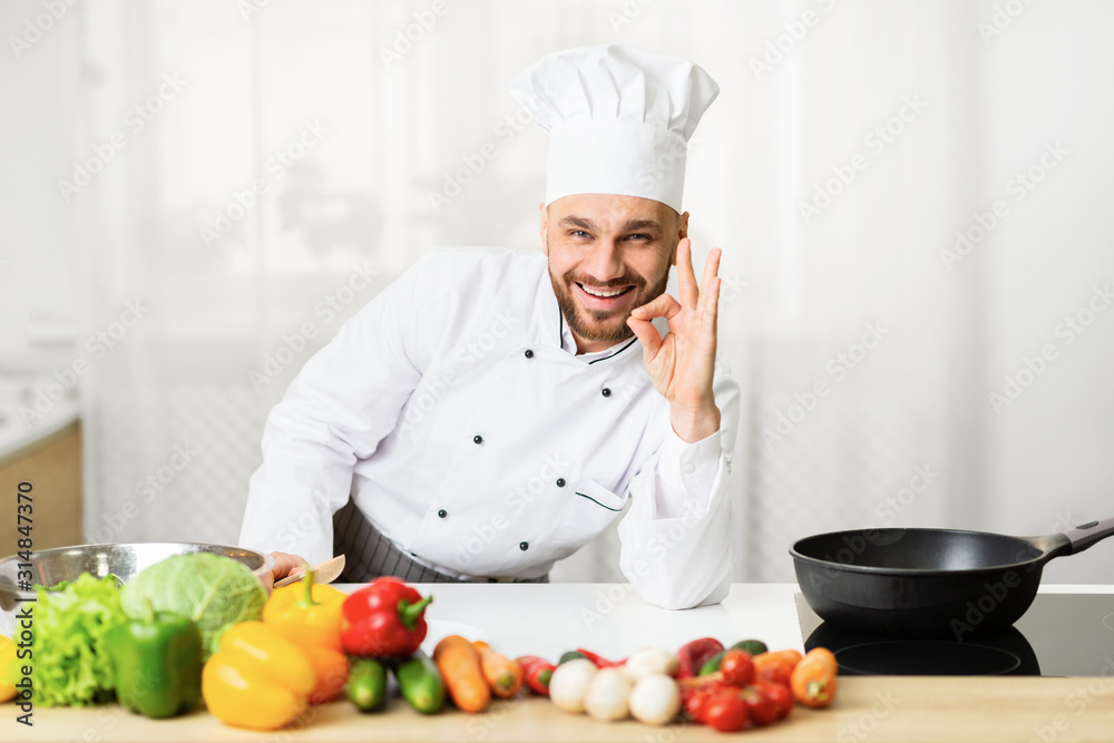 Positive Chef Man Gesturing Okay Standing In Kitchen Indoor Positive Chef Man Gesturing Okay Standing In Kitchen Indoor