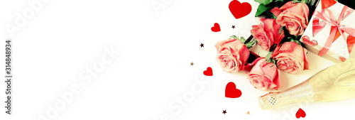 Valentine s day background banner. Bouquet of pink roses flowers  gift box and champagne bottle isolated on white background with copy space toned. Top view flat lay