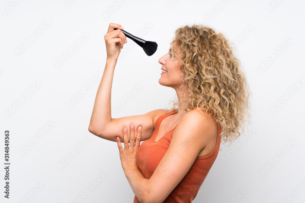 Young blonde woman with curly hair with makeup brush Young blonde woman with curly hair with makeup brush