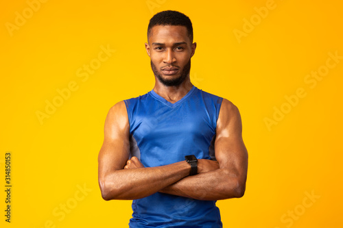 Obraz na plátne Afro sportsman with folded arms at studio