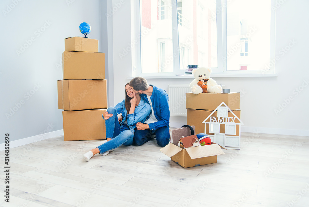 Caucasian couple moving in new home. Young stylish couple in moving in mess. Caucasian couple moving in new home. Young stylish couple in moving in mess.
