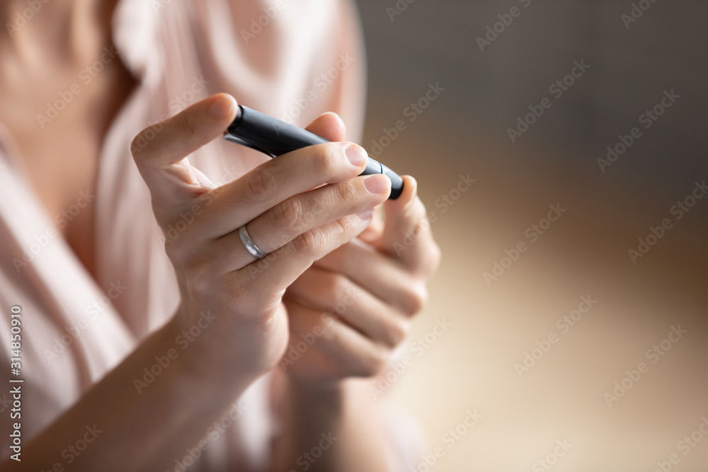 Young woman check blood sugar lever with glucometer Young woman check blood sugar lever with glucometer