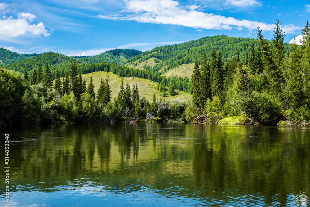 Still river in Sayan mountains in summer sunny day. Siberia, Russia.