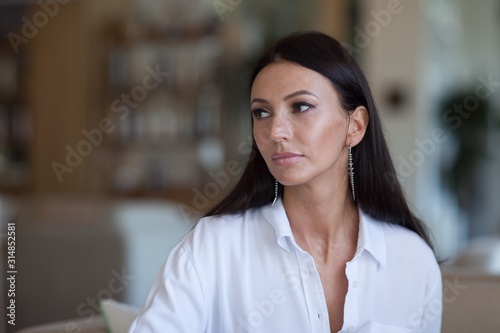 portrait of a girl in a restaurant in a white shirt. Young business woman, boss woman in a cafe.