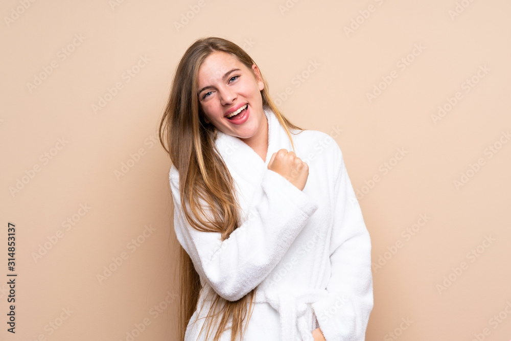 Teenager girl in a bathrobe over isolated background celebrating a victory Teenager girl in a bathrobe over isolated background celebrating a victory