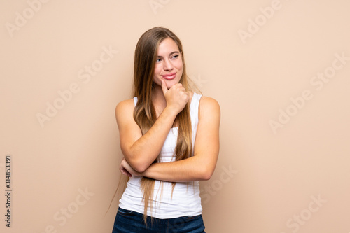 Teenager blonde girl over isolated background looking to the side