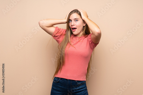 Teenager blonde girl over isolated background with surprise facial expression