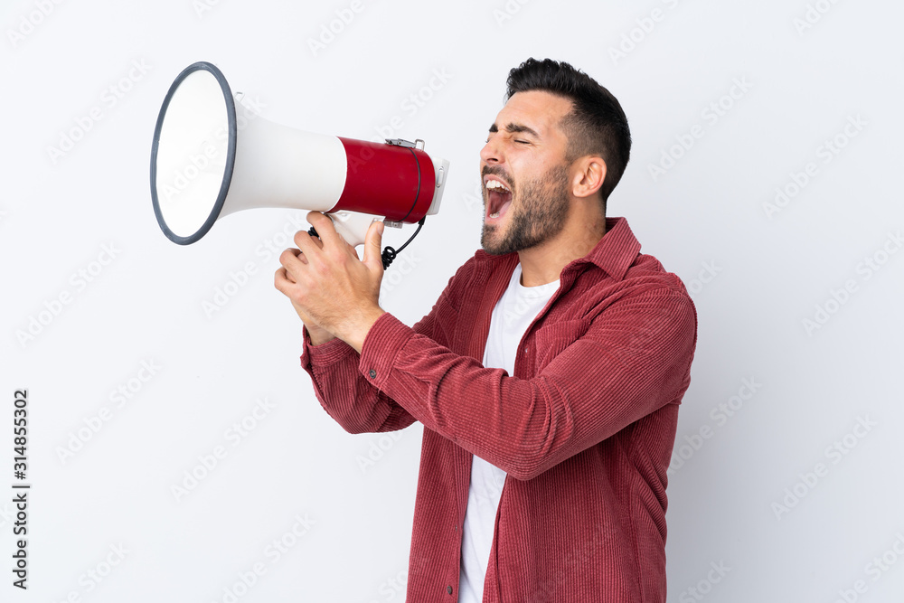 Young handsome man with beard wearing a corduroy jacket over isolated white background shouting through a megaphone Young handsome man with beard wearing a corduroy jacket over isolated white background shouting through a megaphone