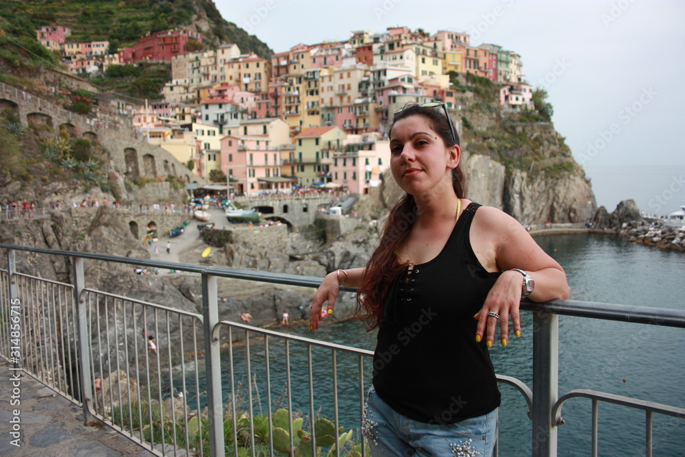 brunette caucasian curvy girl on a lookout point on the Cinque Terre coast in summer