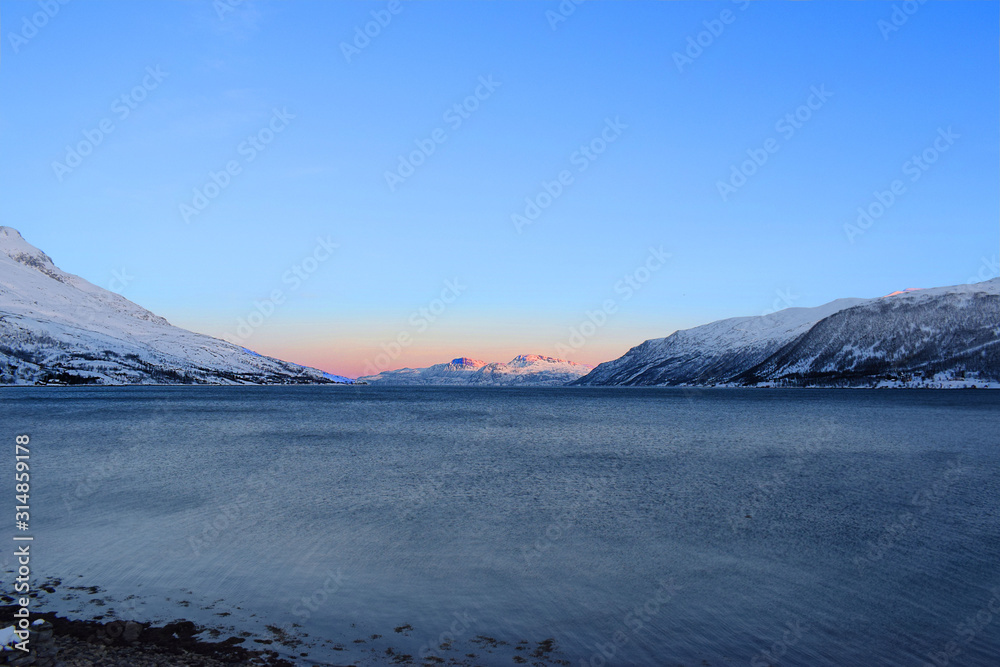 Lake with sun and mountains and fjord