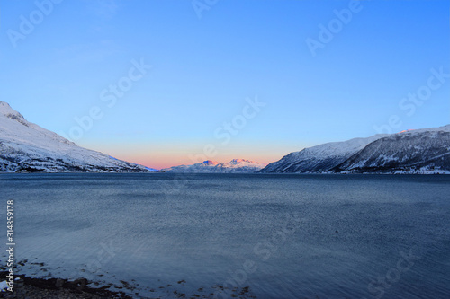Lake with sun and mountains and fjord