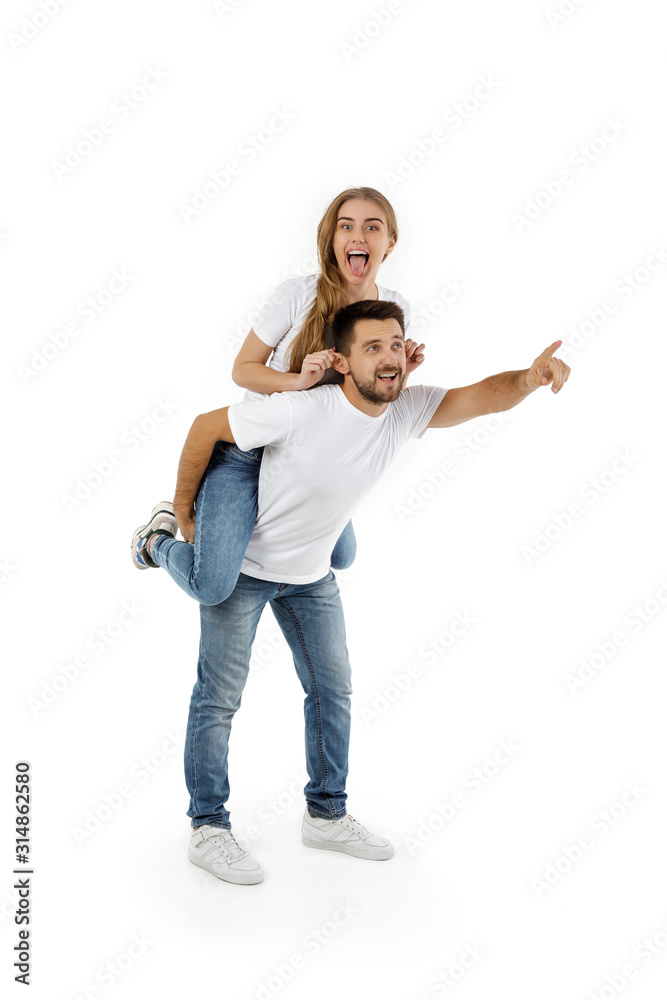 man carrying young woman on his back. boyfriend giving piggyback to girlfriend on white background