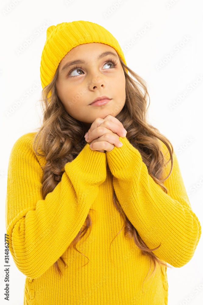 Happy caucasian girl in yellow hat and hoody folded her hands and looks aside isolated on white background Happy caucasian girl in yellow hat and hoody folded her hands and looks aside isolated on white background