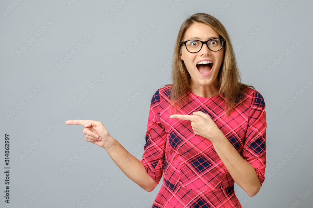 Portrait of amazed and excited brunette female pointing with forefinger Portrait of amazed and excited brunette female pointing with forefinger