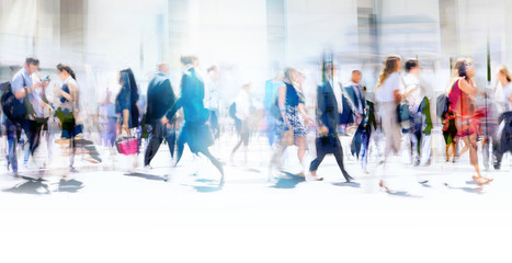 Lots of business people walking in the City of London. Blurred image, wide panoramic view of the crossroad with people at sunny day. London, UK