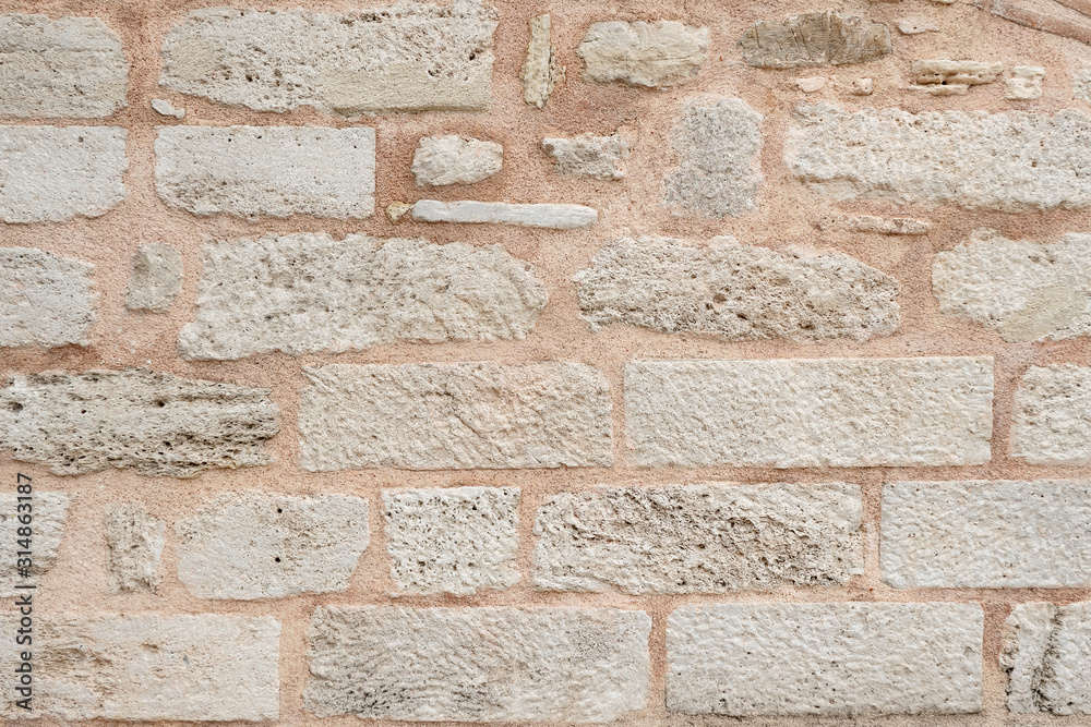 Fototapeta premium wall of the historic building is made of white stones. Texture.