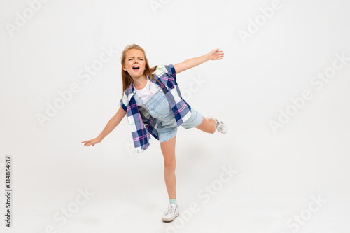 young attractive charming caucasian girl jumping in casual clothes on a light blue studio background