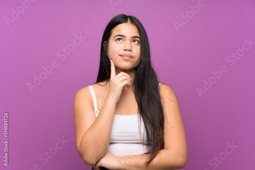 Young teenager Asian girl over isolated purple background thinking an idea